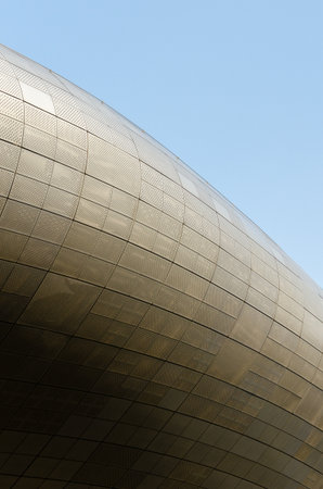 Modern metallic building curve against clear blue skyの写真素材