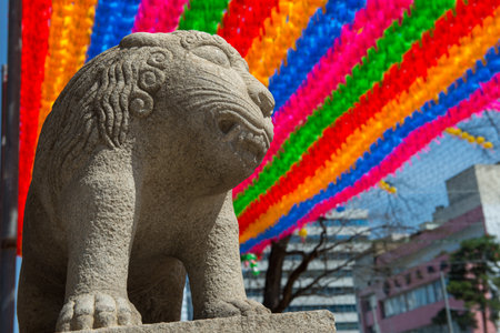 Stone lion under lanterns at a South Korean templeの写真素材