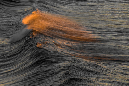 3D rendering of stormy sea waves with orange and yellow lightの写真素材