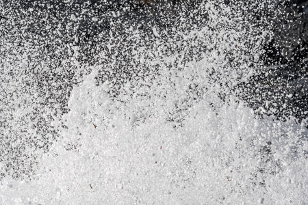 Falling snowflakes on the asphalt as an abstract background.の写真素材