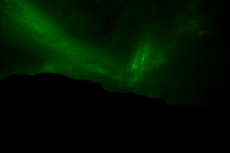 Aurora borealis, northern lights over the mountains in Icelandの写真素材