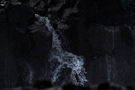 Waterfall in Iceland. Black rocks and white foamy water.の写真素材