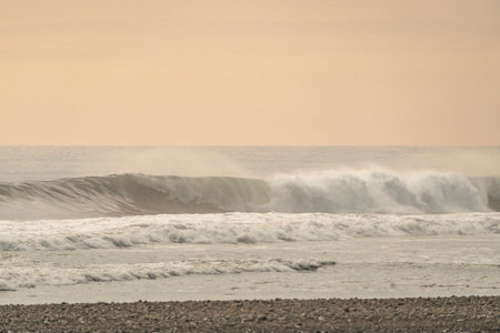 Big wave breaking on the beach at sunset time. Natural background.