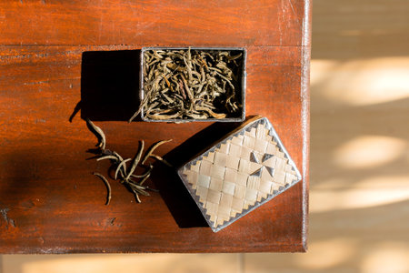 Dried tea leaves in a box on a wooden table, top viewの写真素材