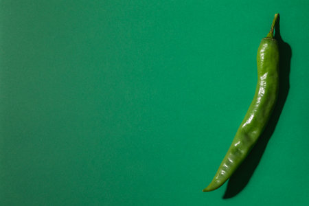Green hot chili pepper on a green background. Flat lay, top viewの写真素材