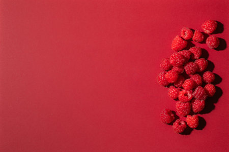 Fresh raspberries on red background. top view with copy spaceの写真素材