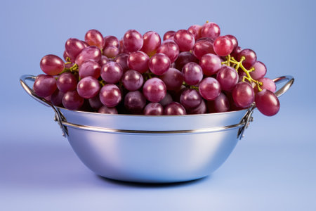 A stainless steel basket filled with sorted grapes isolated on a gradient backgroundの素材