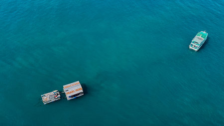 Aerial view of two boats on a tranquil blue sea, depicting concepts of travel, tourism, or leisure