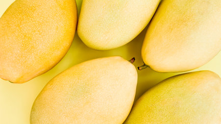 Close up of ripe mangoes on a yellow background with ample space for text, ideal for healthy eating,...