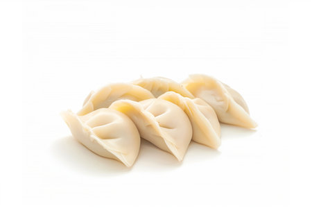 A group of freshly made dumplings isolated on a white background with space for text, perfect for culinary themes and Chinese New Year celebrationsの素材