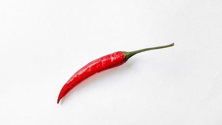 Single fresh red chili pepper isolated on a white background with copyspace, suitable for culinary...