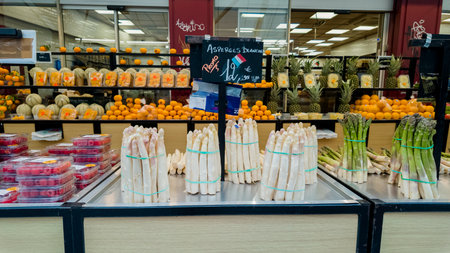 White and green asparagus displayed in a Parisian market, indicating springtime freshness and Easter meal preparations, Paris, France, April 14th, 2024のeditorial素材