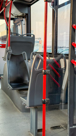 Silent urban bus sanctuary, crimson rails whisper travel tales, echoes of commute amidst musingsの写真素材