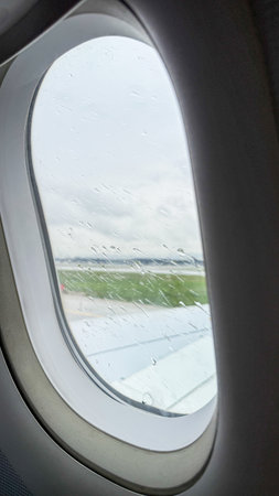Raindrops on airplane window, skyward escape begins, wanderlust ignitesの写真素材