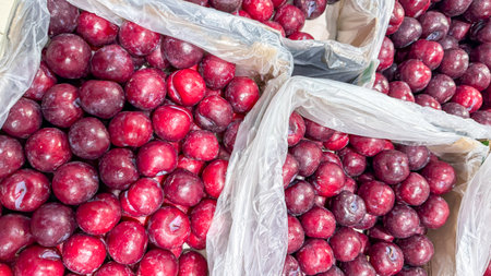 Ripened plums glisten like amethyst orbs nestled in rustic crates, evoking Lammas festival abundance and Yule culinary delightの写真素材