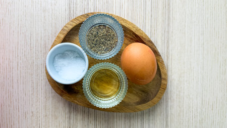 Sunlit breakfast tableau, rustic egg nestled with pepper and mystical salt, akin to springtime Beltane kitchen ritualsの写真素材
