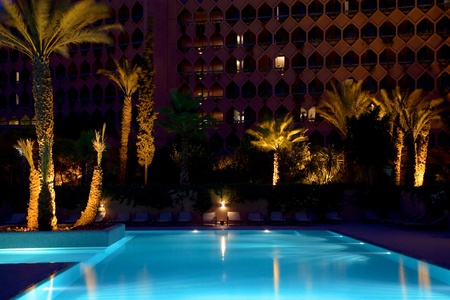 Swimming pool and palm trees in Marrakesh at nightのeditorial素材