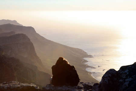 Lovers at the most southwesterly point of Africa in front of a sunset - Table Mountain is a...