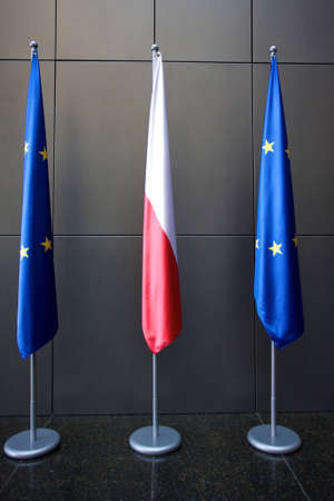 Europe and Polish Flags floating in a European conference in Poland with neutral background