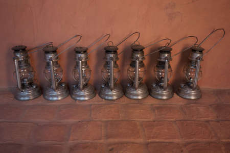 Seven Metal Oil Lamps shot on wall Backgroundのeditorial素材