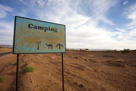 Sign on a desert road to give direction to a campsite in Moroccoのeditorial素材