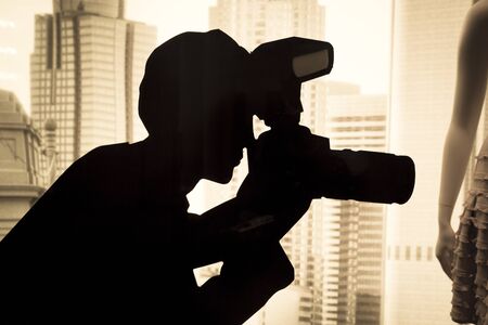 Photographer and model captured in a shadow with blurred city in the background. To symbolise Glamour and modellingの写真素材