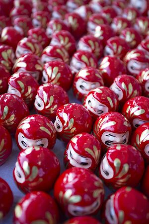 Identical decorative religious objects with eyes painted in red in Tokyo, Japan, Daruma.の写真素材