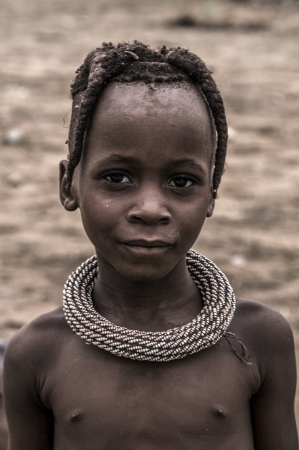 NAMIBIA,KUNENE, JANUARY 7  portrait of a young kid of the Himba people looking at the camera  The Himbas are indigenous people living in northern Namibia, in the Kunene region  formerly Kaokoland  and on the other side of the Kunene River in Angola, Januaのeditorial素材