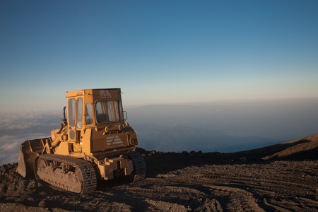 SICILY, ETNA, AUGUST 8: Bulldozer at the top of the Etna with a sunset with the horizon in the backgroundのeditorial素材