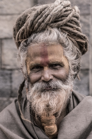 NEPAL, KATHMANDU, APRIL 24: Portrait of an Holy Sadhu man with traditional painted face, praying in Pashupatinath Temple in Kathmandu, Nepal. In Hinduism, sadhu is a common term for a mystic, an ascetic, practitioner of yoga and wandering monks. April 24,のeditorial素材