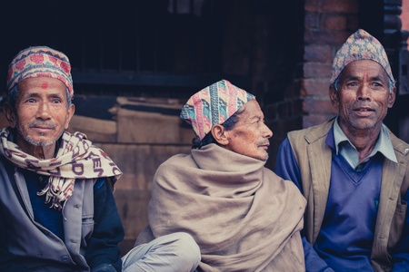 NEPAL, BHAKTAPUR, APRIL 23: A group of Unidentified men with traditional hats in Bhaktapur talking in the street, in the old city.のeditorial素材