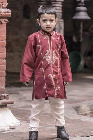 NEPAL, BHAKTAPUR, APRIL 23  portrait of a young kid looking at the camera and dressed to go to a wedding, living in Bhaktapur, April 23, 2013, Bhaktapur, Nepalのeditorial素材
