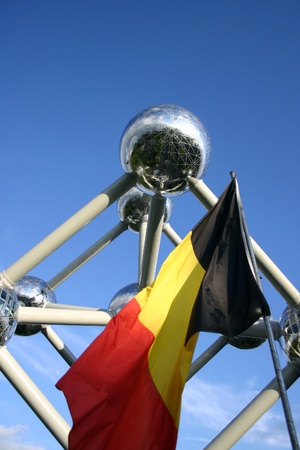 BRUSSELS, BELGIUM, MAY 30: The Belgium main symbol, the Atomium and a Belgian flag with a blue sky in the background, 2013.のeditorial素材