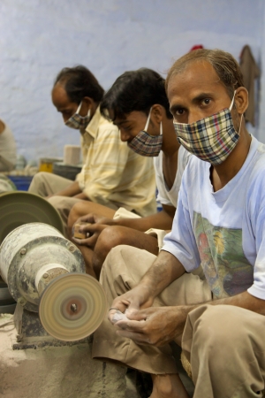 AGRA, INDIA, JULI 19: Unidentified masked artisans working for Tara, a Fair Trade Organization based in Agra, India and specialized in soap stone products, more or less 1000 Artisans work for Tara within ethical rules. India 2013.のeditorial素材