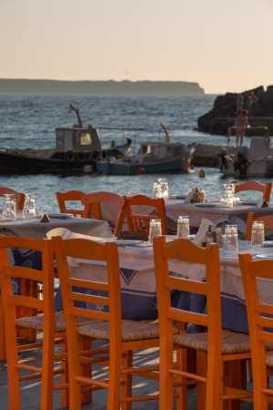 Oia fisher port restaurant and fisher boats in the background, Santorini, Greece の写真素材