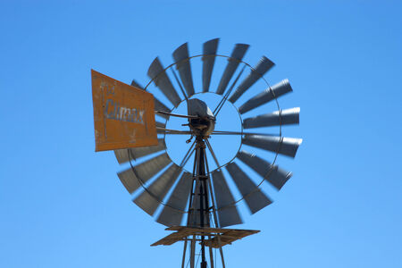 Detail of a bore water wind mill in action with a blue sky somewhere in south africaの写真素材