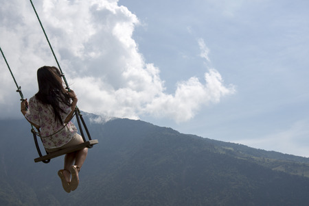 BANOS, ECUADOR - FEB 21: Unidentified young woman swinging at the La casa del Arbol in Banos, Ecuador 2015.のeditorial素材