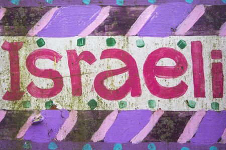 Pink handwriting word Israeli and painted on a wooden board in Costa Rica.
