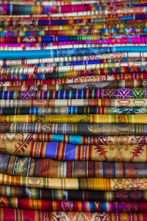 Closeup image of classical colorful Peruvian and Bolvian clothes and handicraft at the indigenous market in Otavalo. Ecuador 2015.の写真素材