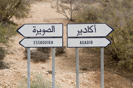Which direction you want to take in Morocco... Road sign in Morocco with bush in the background. Road to Agadair or Essaouiraの写真素材