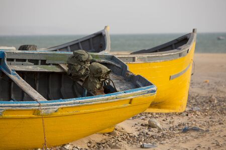 Two yellow and blue fishing boats standing on the beach of Sidi Kaouki near Essaouira in Moroccoの写真素材
