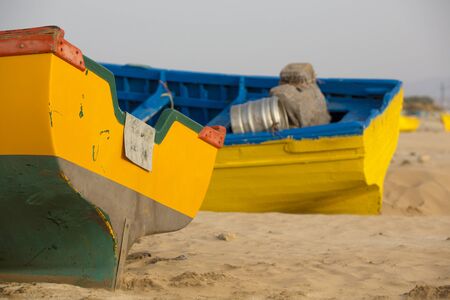 Two yellow and blue fishing boats standing on the beach of Sidi Kaouki near Essaouira in Moroccoの写真素材