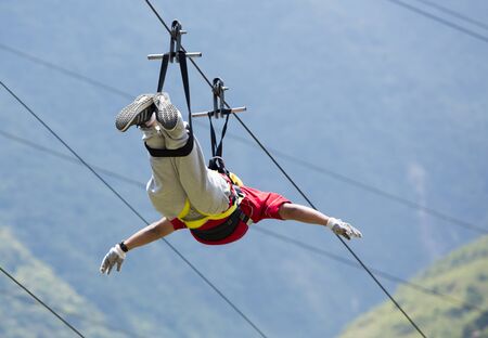 BANOS, ECUADOR, FEBRUARY 21: Unidentified man falling on a zip line adventure park in Ecuadorian rainforest, Banos de Agua Santa, the adventure capital of Ecuador 2015.のeditorial素材