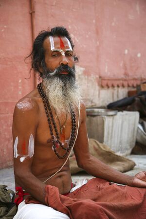 Varanasi, India - June 1, 2009: Unidentified sadhu sitting and meditating on ghat along the Ganges on June 1, 2009 in Varanasi, India. Tourism has drawn many alleged fake sadhus to Varanasi.のeditorial素材