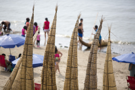 Totora horses called "caballito de totora" in Huanchaco beach with tourists in the background, Peru 2015のeditorial素材