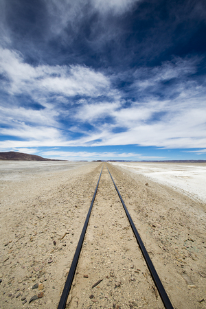 Railway with the desert, blue sky and the mountains in the background in Atacama Desert, Uyuni desert, Boliviaの写真素材