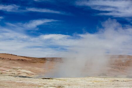 Steam Manana geyser and fumaroles against a blue sky in Bolivia Desertの写真素材