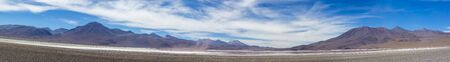 Panorama of mountains and white salt pan in Eduardo Avaroa Andean Fauna National Reserve against a clear blue sky, Boliviaの写真素材