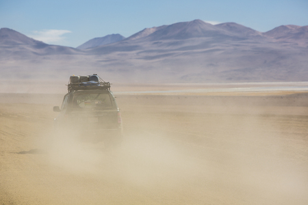 ATACAMA DESERT, BOLIVIA, DECEMBER 31: Off-road vehicle driving in the Atacama desert, Bolivia with majestic colored mountains and blue sky in Eduardo Avaroa Andean Fauna National Reserve, Bolivia 2014のeditorial素材