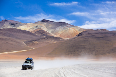 ATACAMA DESERT, BOLIVIA, DECEMBER 31: Off-road vehicle driving in the Atacama desert, Bolivia with majestic colored mountains and blue sky in Eduardo Avaroa Andean Fauna National Reserve, Bolivia 2014のeditorial素材